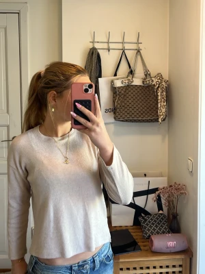 Beige långärmad tröja från Zara - Snygg och enkel beige långärmad tröja från Zara. Tröjan har rund halsringning och är tillverkad i ett mjukt, tunt stickat material som passar perfekt till jeans eller kjol. Stilren design som är lätt att matcha med andra plagg.