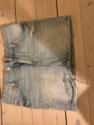 Ljusblå jeanskjol med slitningar - Ljusblå jeanskjol med slitningar nertill på kjolen! Använd på gånger