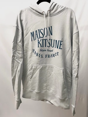 Maison Kitsuné Hoodie - Hoodie från Maison Kitsuné i en snygg ljusblå/grå färg! Nyskick, inga defekter. Står XL men sitter mer som M/L. Modellen är ca 182. Kontakta mig för fler frågor och funderingar!