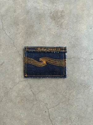 Jeansplånbok - Dropp 6  Handsydd plånbok i vintage jeans. Varje exemplar är unikt med snygga detaljer. Plånboken håller flera kort utan att dem åker ut. Små variationer i färg och struktur visar på plaggets tidigare historia💙  Tiktok: Jeanius.bc