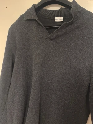 Mörkgrå pikétröja John Henric - Säljer en mörkgrå pikétröja från John Henric i storlek M. Tröjan har klassisk krage och v-ringning, samt långa ärmar. Den är lite skynklig o kragen lite svårt att få den o hålla sig på plats men fixars säkert med en bra strykning. Materialet känns mjukt och är troligtvis bomull eller ullblandning. Perfekt för dig som gillar stilrena och tidlösa plagg. 