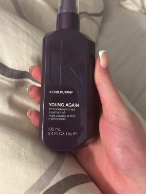 Kevin Murphy Young.Again Treatment Oil - Kevin Murphy Young.Again Treatment Oil är en näringsrik hårolja i en mörklila plastflaska med pump. Oljan är berikad med immortelle och passar perfekt för att ge håret glans och mjukhet. Flaskan rymmer 100 ml och har en modern, stilren design. Nypris 409kr