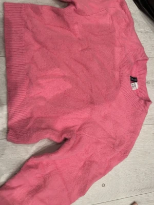 Rosa stickad tröja från Divided/H&M - Mysig rosa stickad tröja från Divided med rund halsringning och ribbade muddar vid ärmslut och nederkant. Perfekt för lager-på-lager och enkel att matcha med jeans eller kjol. Tröjan har en klassisk passform och är supermjuk. Tröjan har legat i en påse full med kläder därav att den ser lite skrynklig ut💕