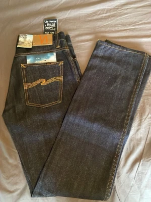 Mörkblå Nudie Jeans - Helt oanvända nudie jeans. De är gjorda i ett väldigt hållbart material som ska hålla i år. Strl, W:29 och L:32. skriv vid någon fundering👑