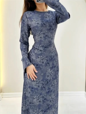 Blommig blå långklänning med snörning - Långklänning i blått med blommigt mönster och långa ärmar. Klänningen har snörning i ryggen för en snygg passform och är tillverkad i ett glansigt material som ger en elegant look. Perfekt för dig som vill sticka ut med stilrena detaljer.