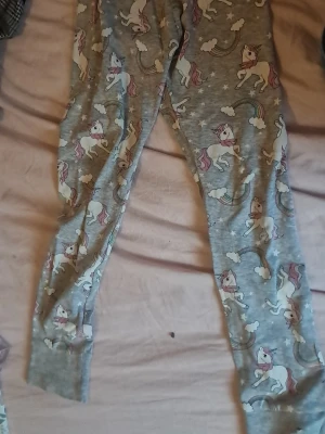 Grå leggings med enhörningar - Superfina grå leggings med gulligt enhörningsmönster och regnbågar. Mjukt material, perfekt för dig som gillar färgglada och lekfulla plagg. Passar dig som vill ha något bekvämt och unikt i garderoben.