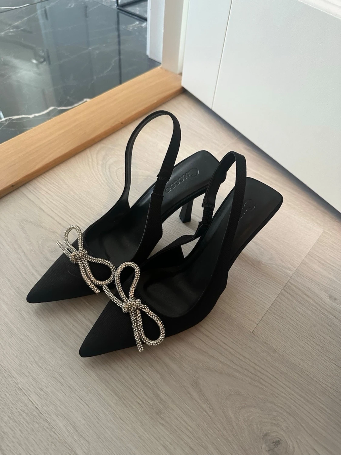 Svarta pumps med strassrosett