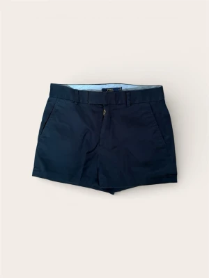 Ralph Lauren Chinos-shorts (Dam) – Strl 6 (S) - Säljer ett par klassiska marinblå chinos-shorts från Polo Ralph Lauren i dammodell. En tidlös modell som passar lika bra på golfbanan som till vardags. Shortsen har en smickrande passform och är tillverkade i högkvalitativ bomull med den ikoniska loggan diskret placerad.  Märke: Polo Ralph Lauren.  Färg: Marinblå.  Storlek: 6 (Motsvarar vuxenstorlek 36/S).  Skick: Mycket . Kommer från ett rök- och djurfritt hem.  Pris: 599 kr.  Finns i Bromma. Snabb och smidig affär prioriteras.