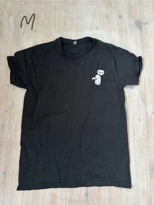 Svart t-shirt med spöke-tryck - Svart t-shirt i bomull med ett litet vitt spöke och texten 'boo' tryckt på bröstet. Klassisk passform och rund halsringning.