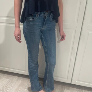 Gina tricot blå bootcut jeans - Snygga blå gina jeans med klassisk bootcut passform., mid waist  har lite utsvängda ben. Passar till allt och ger en schysst siluett. Köpta för 400kr använda ca 2 gånger 