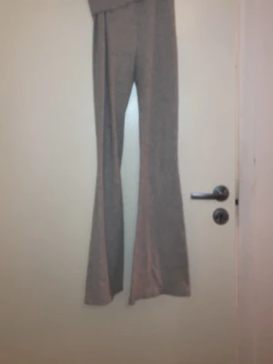 Grå ribbade bootcut leggings - Säljer ett par grå leggings med ribbad struktur och utsvängda ben. De har hög midja och är stretchiga för en bekväm passform. Perfekta till sneakers eller chunky boots. Materialet känns mjukt och följsamt.