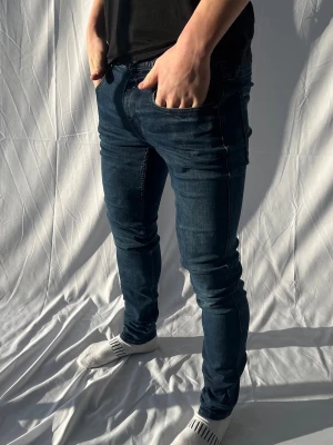 Replay - Snygga mörkblå slim fit jeans med klassisk femficksdesign och stretchigt material som sitter tajt längs benen. Perfekta för en modern och avslappnad stil.