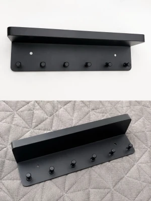 Svart nyckelhängare  med krokar - Snygg svart hylla i hård plast med sex små krokar undertill, perfekt för att hänga nycklar, väskor eller accessoarer. Hyllan har en modern och stilren design och kan enkelt monteras på väggen. Passar i hallen, sovrummet eller köket.