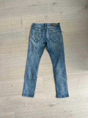 blå jeans - Snygga ljusblå slim fit jeans med klassiska bakfickor och skinnpatch i midjan. Jeansen har en smal passform och raka ben, perfekta till en avslappnad stil. Tillverkade i ett mjukt denimtyg som ger en bekväm känsla hela dagen.