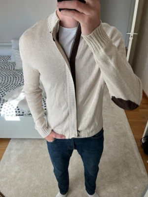 Ljus beige stickad kofta från Massimo Dutti - Säljer en riktigt snygg stickad cardigan från Massimo Dutti med snygga bruna läder patches vid armbågarna. Tröjan är i väldigt fint skick! ✌🏼—————————————————————————                                                                      📐| Storlek: M                                                           👖| Märke: Massimo Dutti                                      🔎 | Skick: Fint skick                                                  ✍🏻 | Skriv om du har några frågor