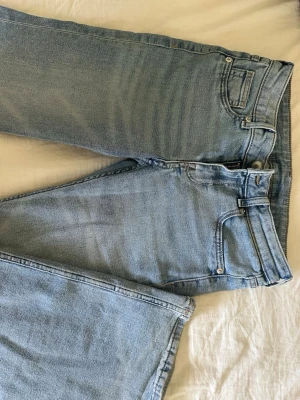 Ljusblå bootcut jeans  - Säljer ett par ljusblå jeans med bootcut passform och klassisk femficksdesign. Jeansen har normal midja och dragkedjegylf. Materialet är denim i bomull och de har en tidlös look som passar till det mesta.