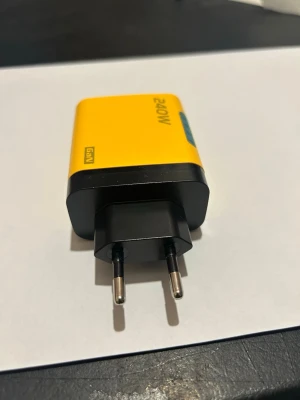 Gul 240W USB-laddare med flera portar - Gul och svart USB-laddare med GaN-teknik och 240W effekt. Utrustad med tre USB-C portar och två USB-A portar för snabb laddning av flera enheter samtidigt. Perfekt för mobiltelefoner och tillbehör.Om du köper fler saker från mig så kan jag göra sammafrakt .