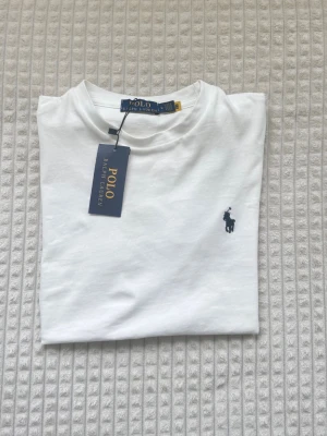 Polo Ralph Lauren tee - 🐎 Polo Ralph Lauren T-Shirt – White 🤍  • ✨ Brand new with tags attached • 🐎 Classic embroidered Polo logo on the chest • 🤍 Clean and versatile white color • 👕 Tagged size M • 🌿 Soft and comfortable premium-quality material • 📦 Comes with original packaging • ✅ Unworn and in excellent condition  💰 Price is negotiable – feel free to send an offer! 📏 Feel free to message me if you’d like measurements. 💌 Fast shipping and happy to answer any questions. ✨