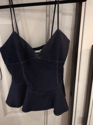 Mörkblå peplum linnetopp zara - Snygg mörkblå linnetopp med smala axelband och peplumvolang nedtill. Toppen har markerade sömmar och en v-ringad skärning framtill. Perfekt för dig som vill ha en trendig och feminin look. Från Zara aldrig använd passar tyvärr inte mig💕