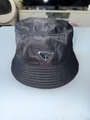 Prada hat svart - Svart Prada hat kommer i nyskick skriv för mer bilder osv kan mötas i Sthlm även frakta priset går alltid att prutta vid snabbaffär 
