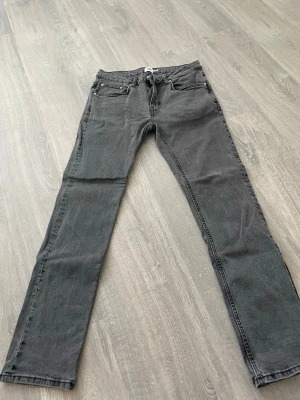 Grå lager 157 jeans - Snygga grå jeans med slim fit passform och klassisk femficksdesign. Jeansen har bälteshällor och dragkedjegylf. Perfekta till en avslappnad streetstyle-look. Materialet är denim i bomull.
