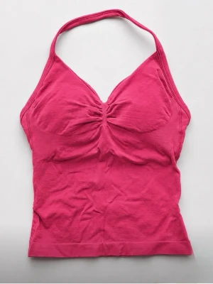 Berry red halterneck träningstopp - Säljer en snygg berry red träningstopp med halterneck och rynkad detalj vid bysten. Toppen är ärmlös och har en figurnära passform. Materialet känns mjukt och stretchigt och passar som XS-S🥰
