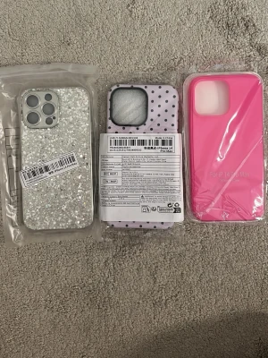  mobilskal till iPhone 14 Pro Max - Säljer tre olika mobilskal till iPhone 14 Pro Max: ett glittrigt silverfärgat skal, ett lila skal med svarta prickar och ett helrosa skal. Helt nya och oöppnade, råkade beställa för fel mobil😭 Jättefina, från Shein