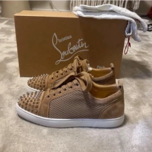 Christian Louboutin Skor/Sneakers Beige  - Snygga beige sneakers från Christian Louboutin med meshpaneler och mockadetaljer. Skorna har vita sulor och coola silverfärgade nitar på tån. Perfekta för dig som vill sticka ut med en lyxig och edgy stil. Enstaka event 10/10 skick och passar till det mesta. Bättre pris finns nog inte, har lyckats få ned priset så gott jag kan för att få bästa möjliga kund krets och nöjdhet är mer värt än pengar hos oss! Ta vara på chansen då vi endast publicerar enstaka annonser här på plick. Först till kvarn