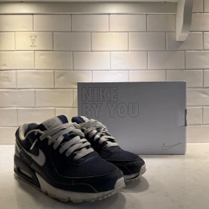 Nike Air Max 90 mörkblå/vita sneakers - Nike Air Max 90 sneakers- Nike By You. Egen designade skor i mörkblått och vit från Nike. Storlek 41, nypris 1999, bra skick, använda en del. Säljer för 400 kronor i Stockholm med originalkartong. 