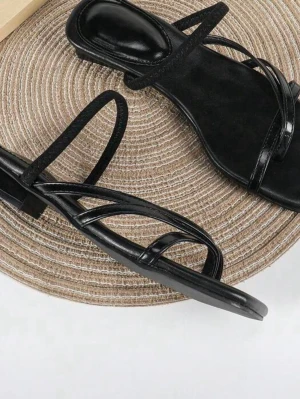 Svarta sandaler med remmar - Stilrena svarta sandaler med tunna, glansiga remmar och fyrkantig tå. Sandalerna har låg klack och en minimalistisk design som passar perfekt till sommarens outfits. Materialet ser ut att vara syntetiskt läder och de har en modern look.