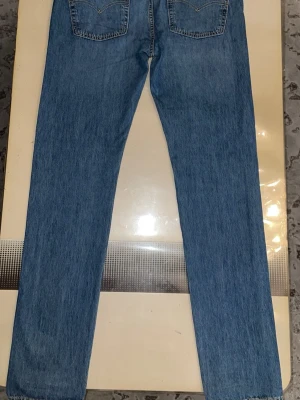Levi's Premium raka blå jeans - Säljer ett par klassiska raka blå jeans från Levi's Premium. Jeansen har två bakfickor med snygga sömmar och är tillverkade i slitstark denim. Perfekta för dig som gillar tidlös stil och vill ha ett par jeans som funkar till allt.