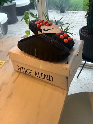 Nike Mind 001 Slides - Svart/orange - Populära nike mind som är slutsålda överallt och mycket eftertraktade. Storlek 42 men passar även lite mindre. Box och original tags medföljer.