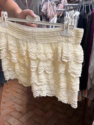 Beiga shorts med volang och spets - Supersöta beiga strandshorts med flera lager volanger och detaljerad spets. Perfekt för dig som vill ha en feminin och somrig look.