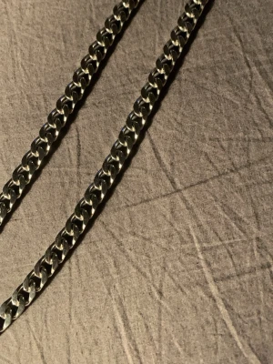 Kedjehalsband i silverfärg - Snyggt pansarhalsband med breda, platta länkar i silverfärgad metall. Kedjan har en klassisk och stilren design som passar till många olika looks. Perfekt accessoar för dig som gillar en enkel men ändå statement stil.