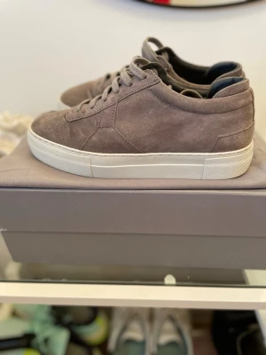 Grå mockasneakers från Axel Arigato - Stilrena sneakers i grå mocka från Axel Arigato med vit tjock sula och diskret logga på sidan. Dustbag kvitto och allt original ingår. 