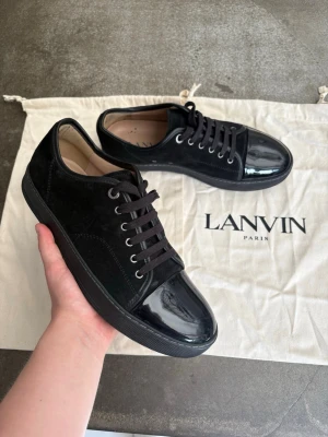 Lanvin Captoe DBB1 med glans  - Säljer nu mina riktigt sköna Lanvin DBB1 Captoe i färgen Black/Black! Storlek: Uk8 - motsvarar 42/43  Otroligt sköna, väldigt sparsamt använda. Har använt kanske 2-3 gånger…. Liten missfärgning på insidan av sulan men det märks verkligen inte när man bär dem!✅  ✅Köpte de nya ifrån Care of Carl!🤗 ✅Självklart äkta ✅9,5/10 skick  ✅2st dustbags medföljer  Snabb affär = priset sänks💰 📦 Alltid frakt inom 24h🚚  