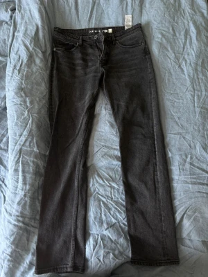 Svarta raka jeans från Cortefiel - Snygga svarta jeans från Cortefiel med rak passform och klassisk femficksdesign. Jeansen har normal midja och är tillverkade i ett mjukt denimtyg som ger en skön känsla. Perfekta för dig som gillar en enkel och stilren look.