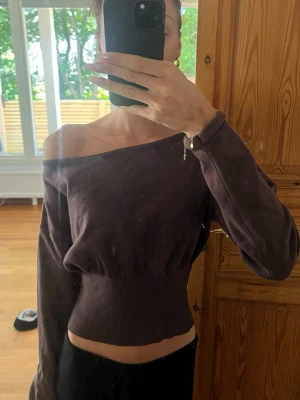 Brun offshoulder croppad topp - Trendig brun croppad topp med offshoulder-design och långa ärmar med åtsittande midja. 