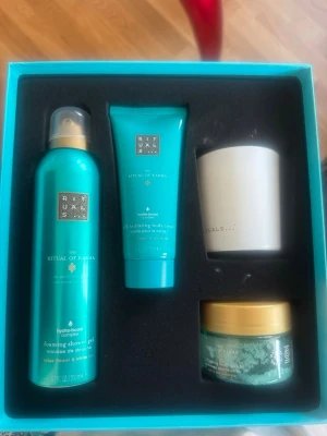 Rituals The Ritual of Karma presentbox - Lyxig presentbox från Rituals med serien The Ritual of Karma. Innehåller duschskum, body cream, kroppsskrubb och ett doftljus. Alla produkter har en fräsch lotusdoft och kommer i turkosa och vita förpackningar med gulddetaljer. Perfekt för dig som vill unna dig lite extra self-care.