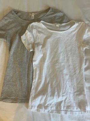 Två basic t-shirts från H&M strl xs - 75kr st 100kr  för båda. Säljer två klassiska t-shirts från H&M, en i vitt och en i ljusgrått. Båda har rund halsringning och korta armar. Båda är i storlek xs