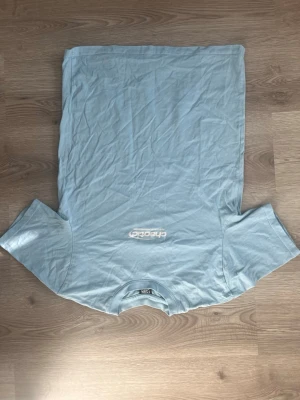 Ljusblå t-shirt från FSBN - Snygg ljusblå t-shirt från FSBN med relaxed fit och diskret tryck på bröstet. Klassisk rund halsringning och korta ärmar. Perfekt för en chill och enkel stil. Storlek XS kan vara lite stor i storleken beronde på hur löst man vill att den ska sitta Skick 10/10