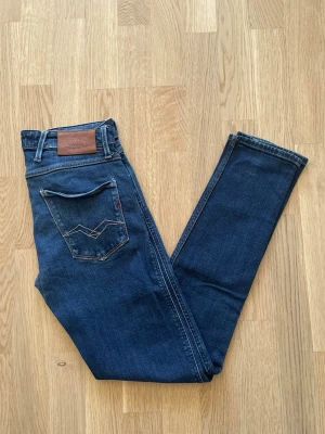 Blå Replay Anbass jeans W29 L32 - Jag säljer dom här blåa Replay Anbass jeansen i storlek W29 L32. De är i fint skick utan defekter. Tveka inte att höra av er!                                   Mått: Längd=101cm. Midja=39cm