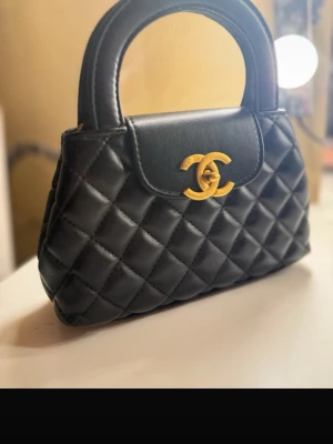 Handväska - Fint skick. Replika. Har ett långt axelband också.