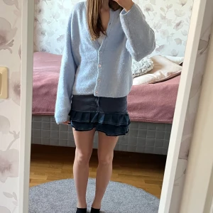 Blå jeanskjol med volanger - Superfin blå jeanskjol från Gant med dubbla volanger som jag har sytt från ett par shorts. Kjolen har en normal passform och är kort i modellen. Stussvidd 78cm. Perfekt för en trendig look!