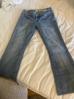 Ljusblå bootcut jeans från LTB - Säljer ett par ljusblå bootcut jeans från LTB med klassisk femficksmodell och låg midja. Jeansen har en snygg tvättad look och är tillverkade i mjukt denimtyg. Perfekta för en avslappnad och trendig stil. Använd typ 3 gånger har oxå insytt snöre vid midjan så man kan tajta till om man vill!