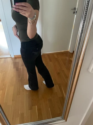 Svarta bootcut jeans med broderi - Säljer ett par svarta bootcut jeans med snyggt broderi på bakfickorna. Säljer då de inte kommer till användning💕