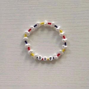 Djurgården Armband  Set 💙❤️ Nytt armband görs vid varje köp! - Säljer ett handgjort armband med vita, röda, gula och blå pärlor samt bokstäverna D I F. Armbandet har en elastisk tråd och pärlor i olika former, vilket ger en lekfull och personlig stil.