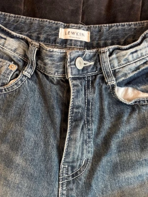 Baggy jeans från Lewkin - Säljer ett par trendiga jeans från Lewkin i populär streetwear stil. Modellen är baggy/straight med snygg washed blek stil.  Sitter löst och bekvämt. Helt nya samt trendiga och svåra att få tag på i Sverige.