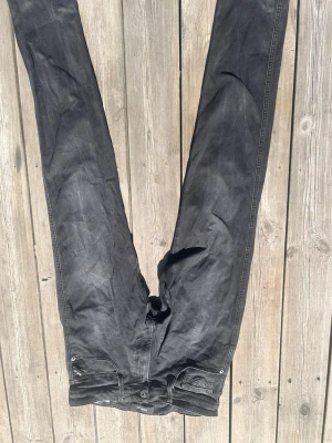 Svarta jeans med broderade bakfickor - Säljer ett par replay anbass svarta jeans i storlek 32