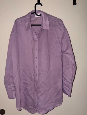 Ljuslila skjorta med knappar - Säljer en stilren ljuslila skjorta med klassisk krage och knäppning framtill. Använd ett fåtal gånger!